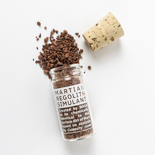 A vial of the simulated Mars soil with the simulant pouring out