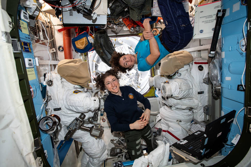 two female astronauts floating on the international space station